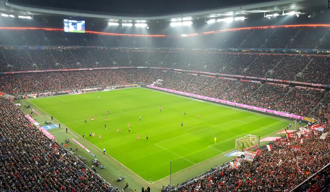 Allianz Arena during a soccer match, showcasing the green field and large crowd